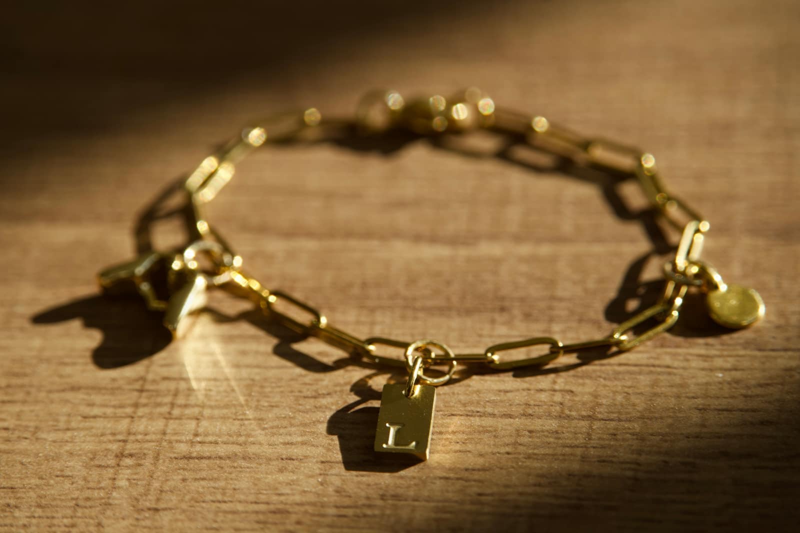 Goldenes Gliederarmband mit individuellen Charms und graviertem Buchstaben-Anhänger