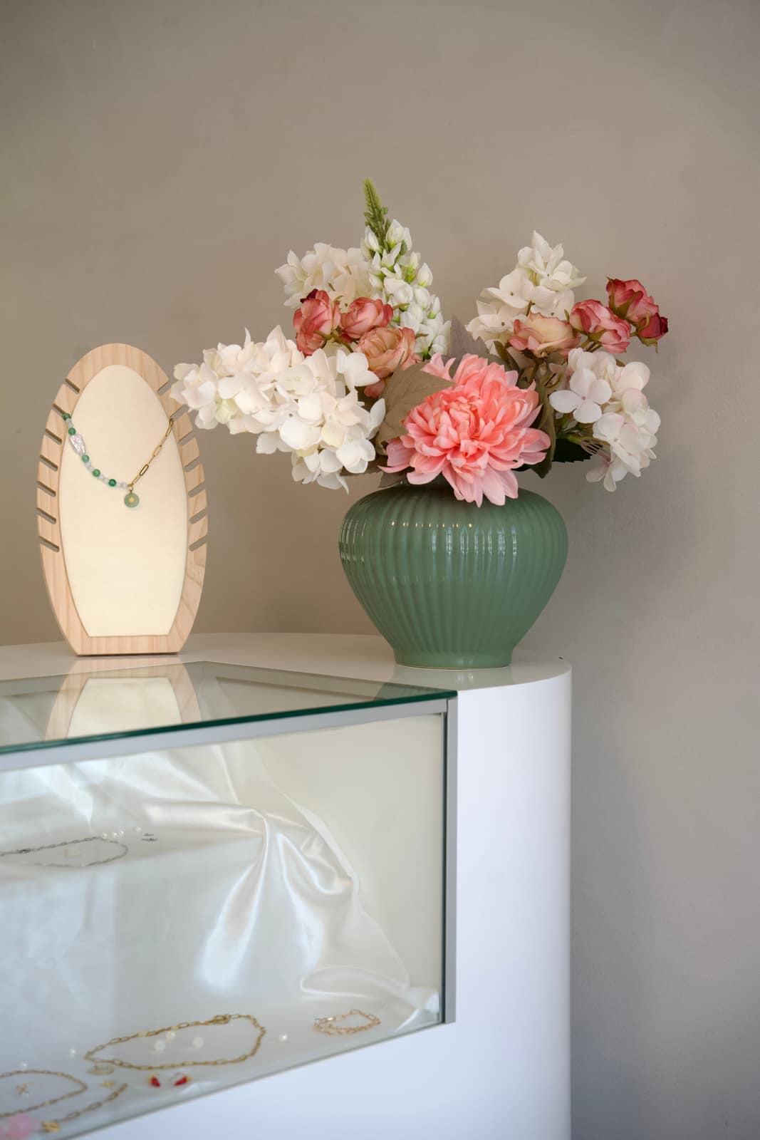  Kettenständer neben einer grünen Vase mit Blumen im Studio